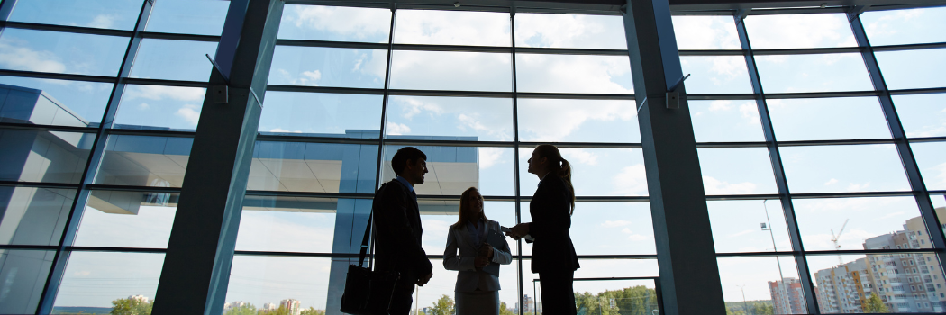 Three people standing in business centre and talking