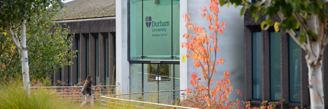 Entrance to Business School in Autumn with a student entering