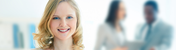 A young woman business intern standing smiling and holding papers