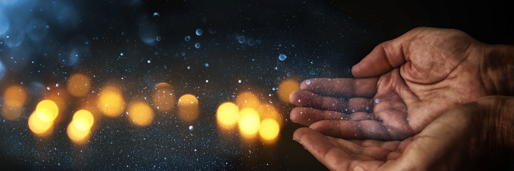 Close-up two empty human hands held out begging in the dark with lights in the background