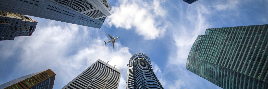 Plane in the sky surrounded by skyscrapers