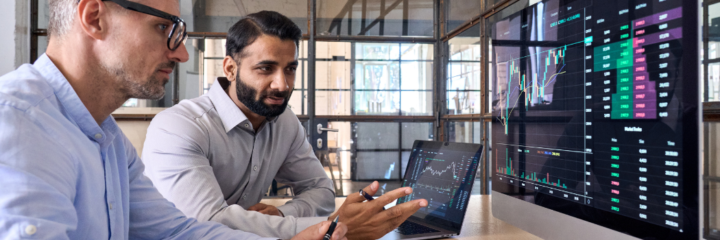 Two male stock exchange investors analysing trading charts