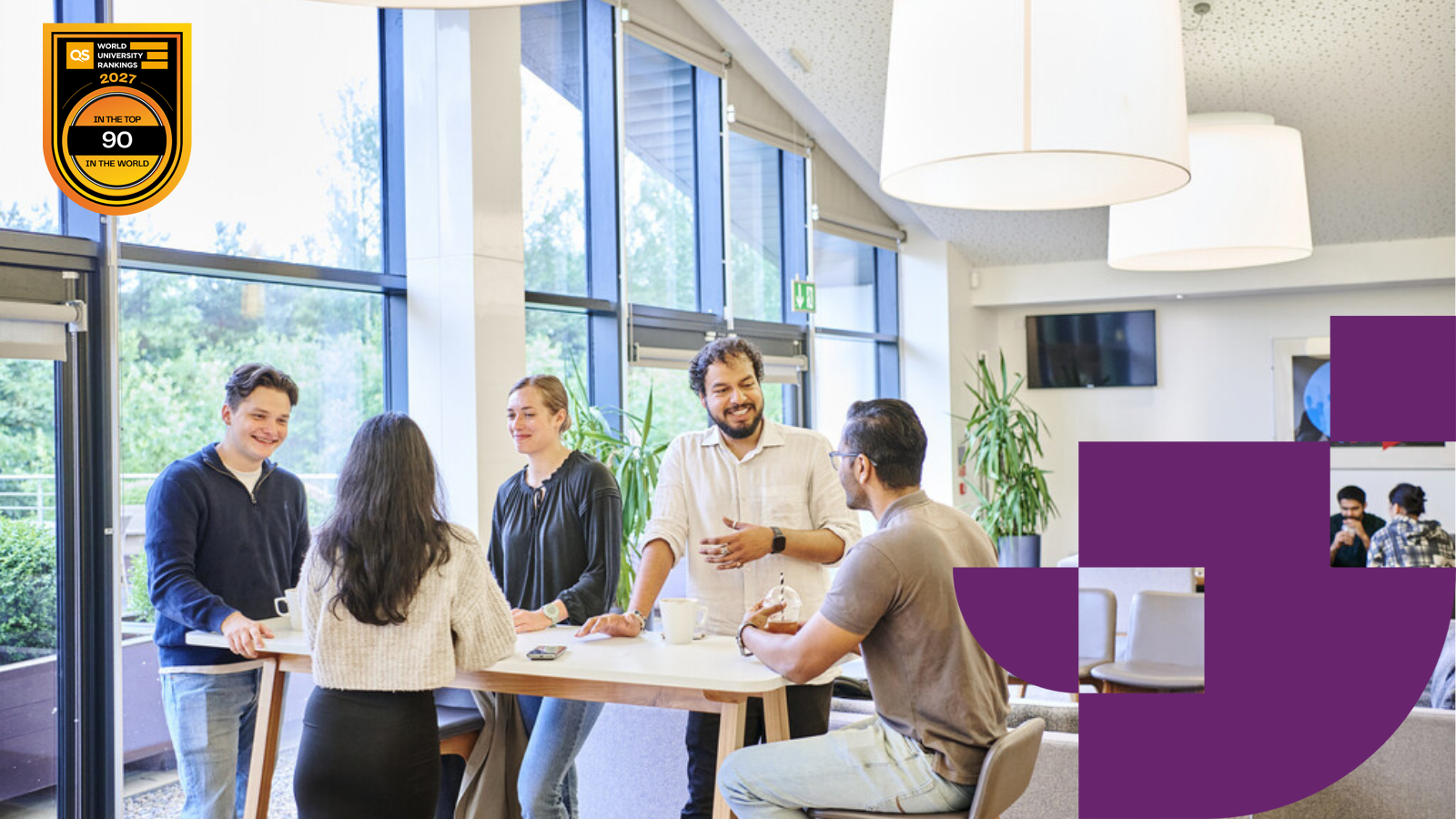 Students around a stand up table talking and smiling with QS WUR 2027 logo in top right