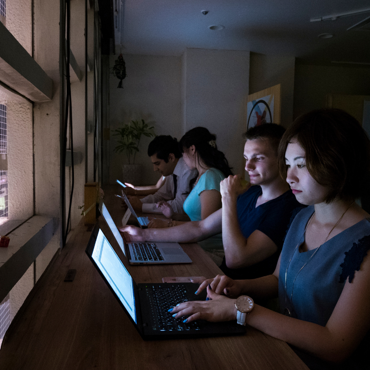 People on laptops on a long study bench