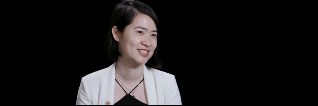 Dr Nikita Chui, photographed against a black background, smiling slightly off camera to the right