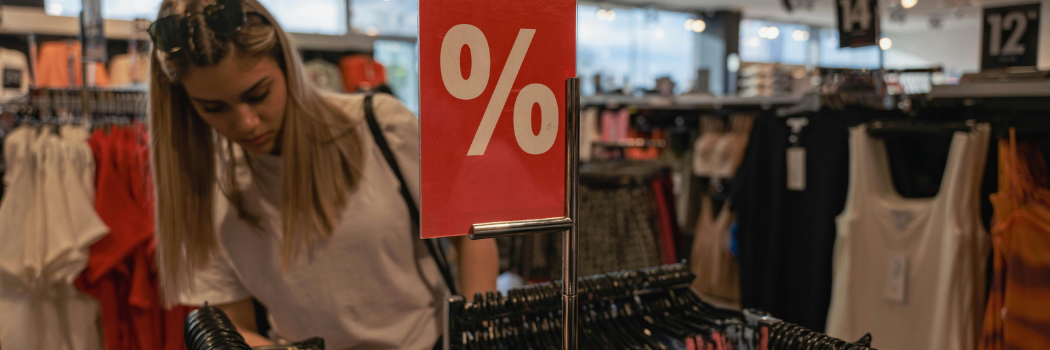 Young woman browsing clothes on sale