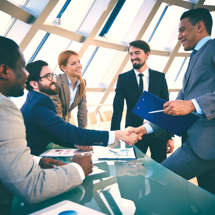 TA group of business people shaking hands across a table