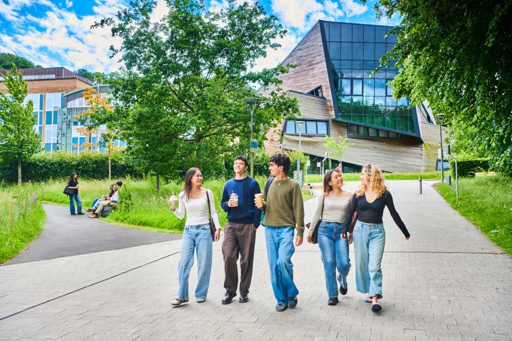 Group of five students walking down from the Ogden Centre smiling