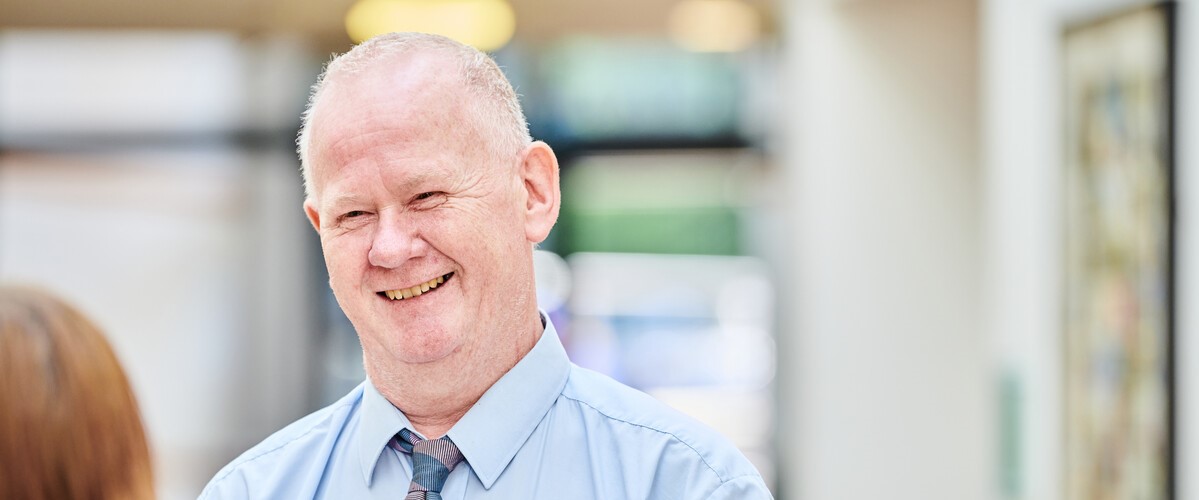 A smiling member of staff engaging in conversation