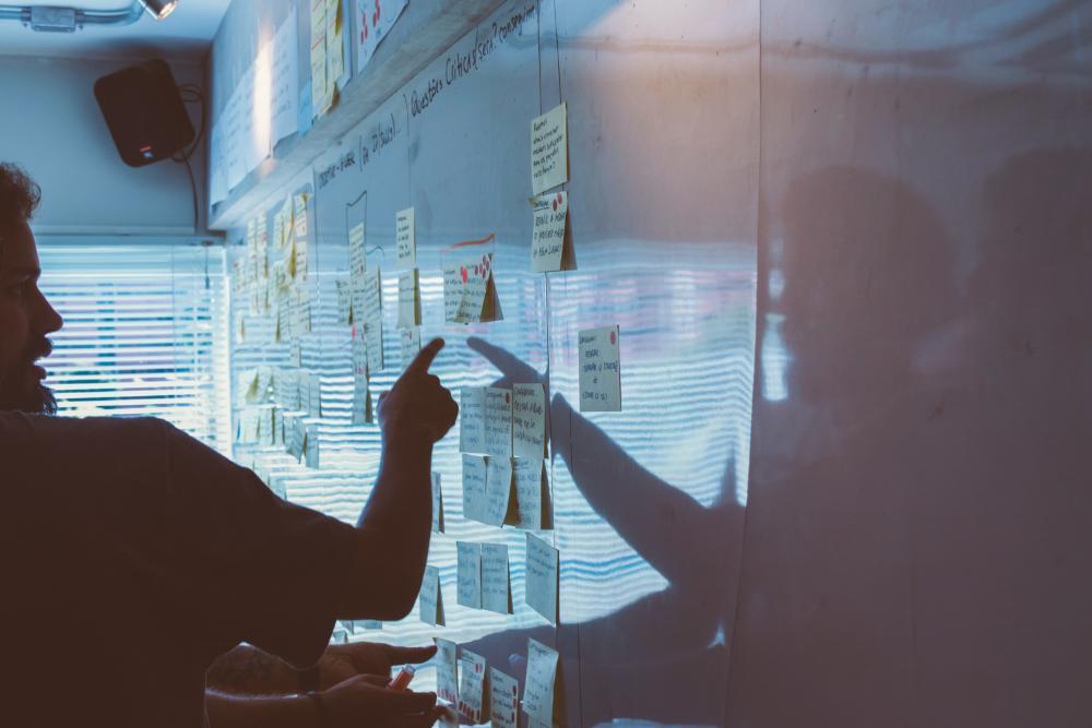 people pointing at plan on whiteboard