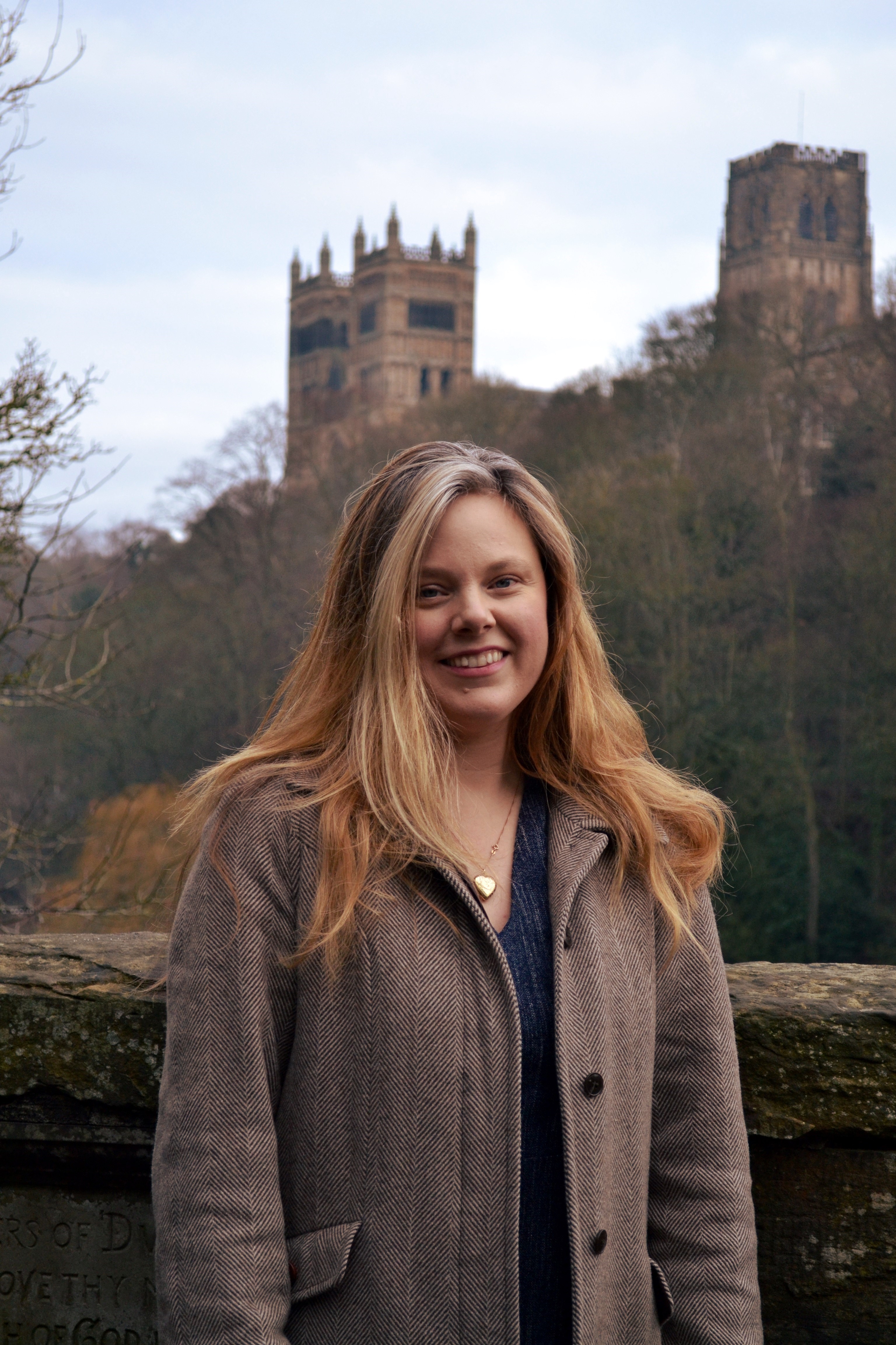 Emily Chester stands on the Prebends Bridge with the view of the cathedral in the background