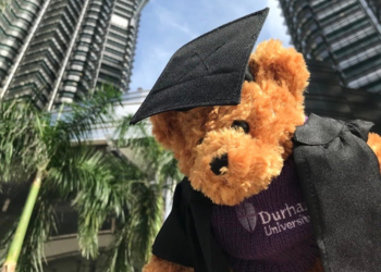 Durham teddy in front of skyscraper