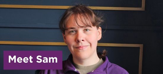 Sam in purple jumper smiling at camera