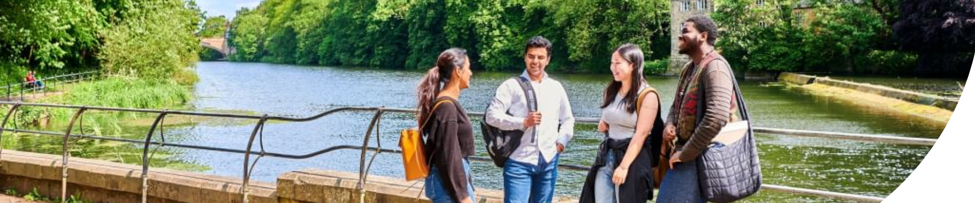 A group of students stood by Durham riverside chatting