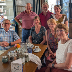 7 alumni posed around a table following a celebratory lunch