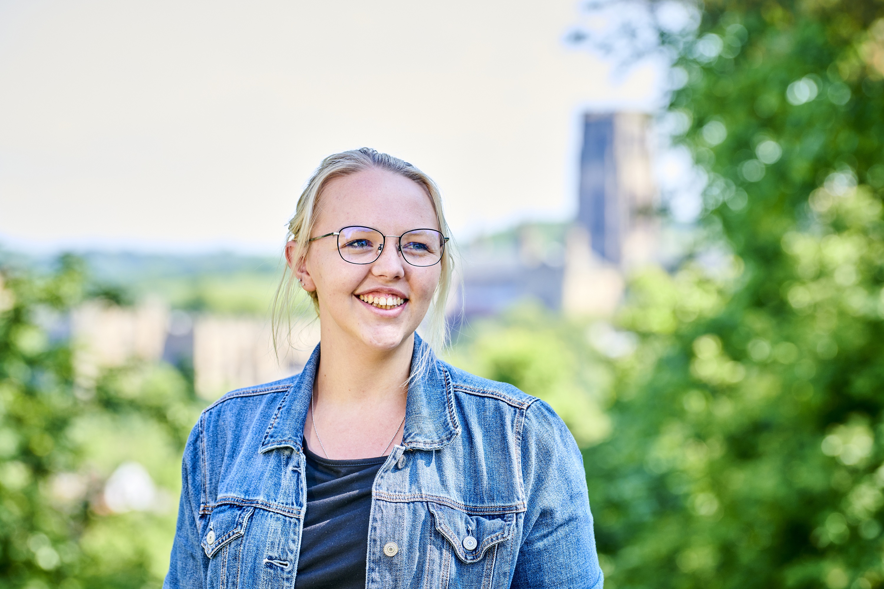 a person wearing a blue shirt and smiling at the camera