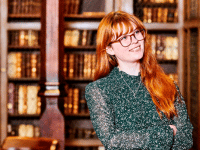 Student in Cosins Library with books in the background