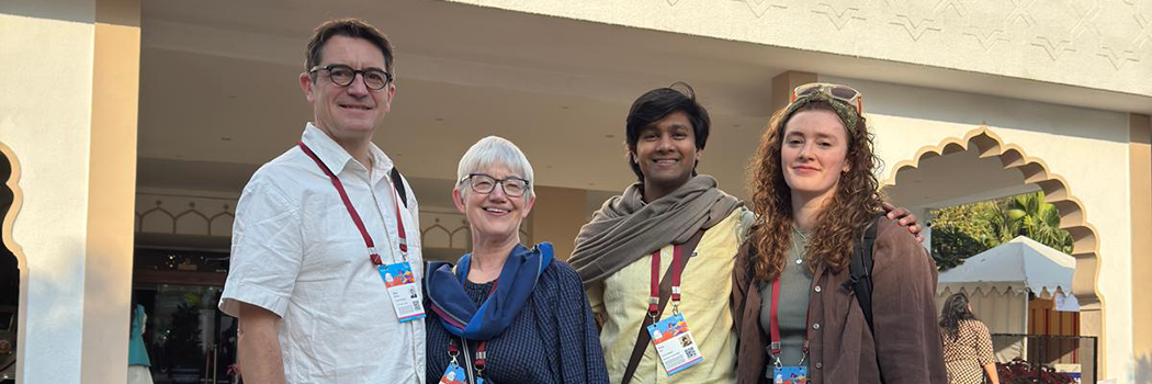 Four people standing smiling at the camera