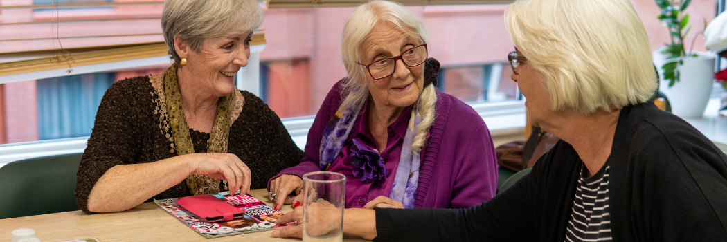 Three older women chatting to each other.