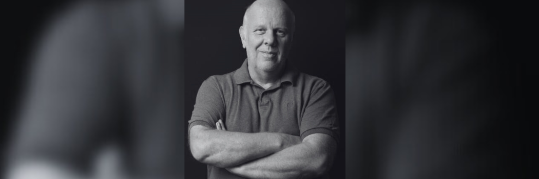 Black and white image of Professor Stephen Gorard with his arms cross smiling to camera