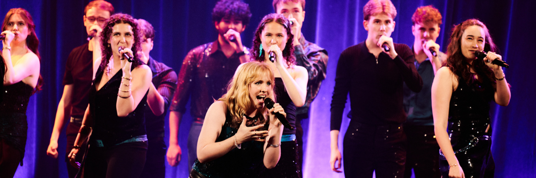 Members of Northern Lights A Cappella in action on stage.