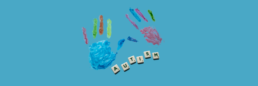 A blue background with multicoloured hand painting print and tiles that read autism