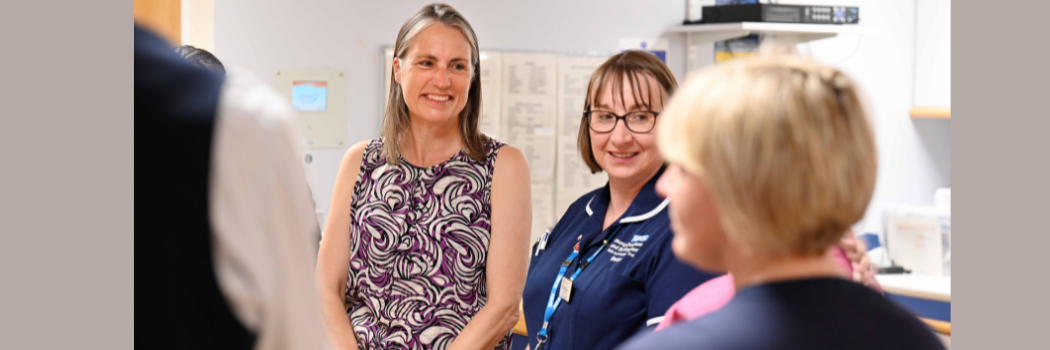 Chancellor Dr Fiona Hill smiling with two nurses