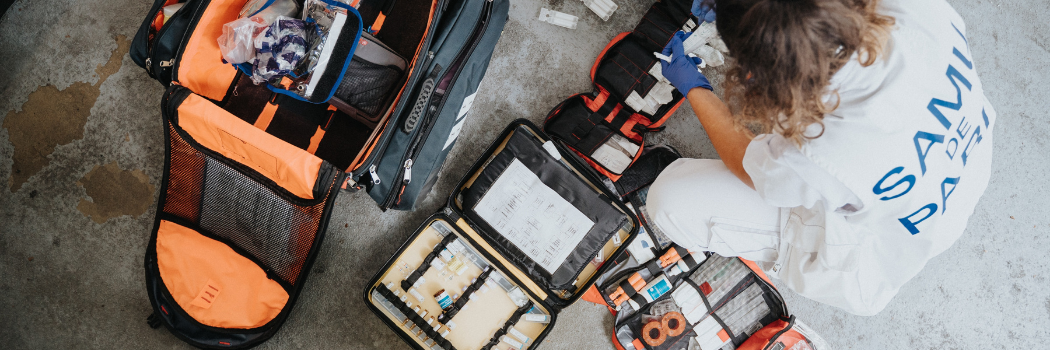 Aerial of female medic with first aid equipment on floor