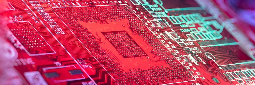 Vivid red circuit board featuring intricate microchip patterns and connections.