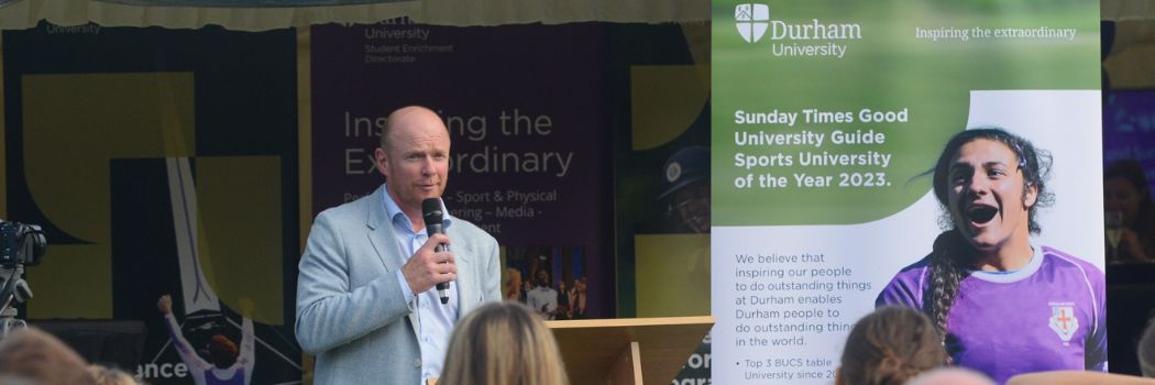 A speech is held in front of banners