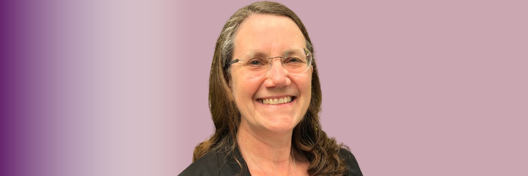 An image of Charlotte Clarke smiling, on a purple background