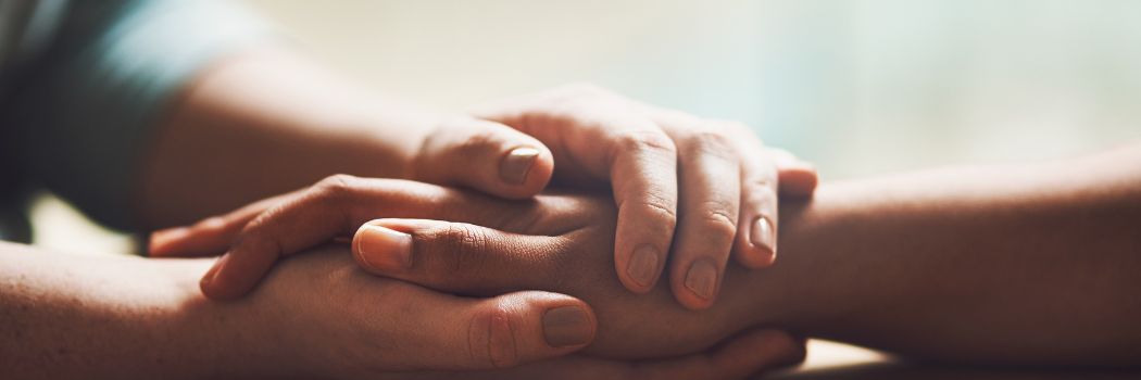 A couple holding hands in a comforting way