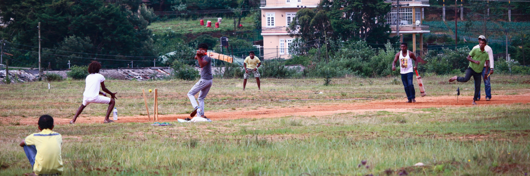 Sri Lankan children playing cricket. A batter has hit the ball.