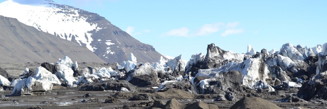 A glacier in the foreground with mountains in the background.