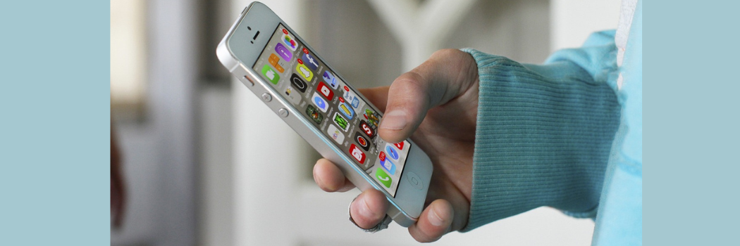 A close up of a person holding a phone with apps displayed on the screen