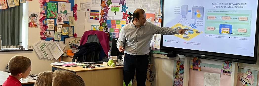 Dr Farshad Arvin points to a screen of his robot presentation in front of pupils