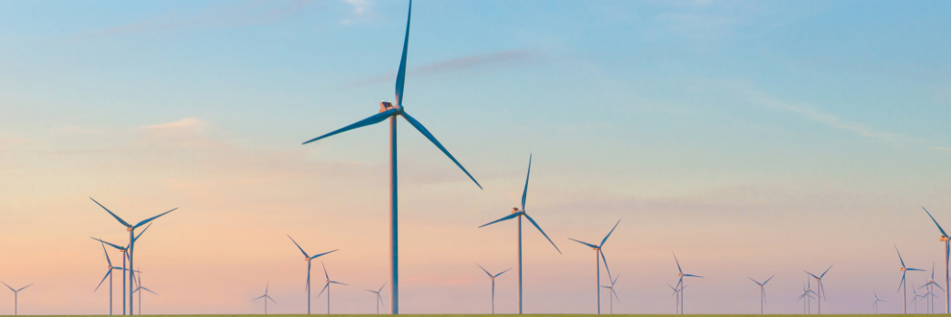 Group of windmills for electric power production in the green field of wheat