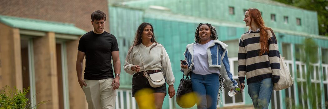 Four young people walking and chatting