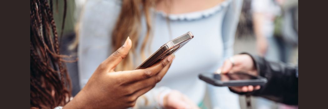 Several hands holding mobile phones