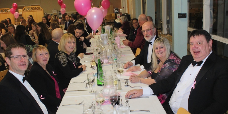 A group of senior members of the college in black tie having an evening meal in college.