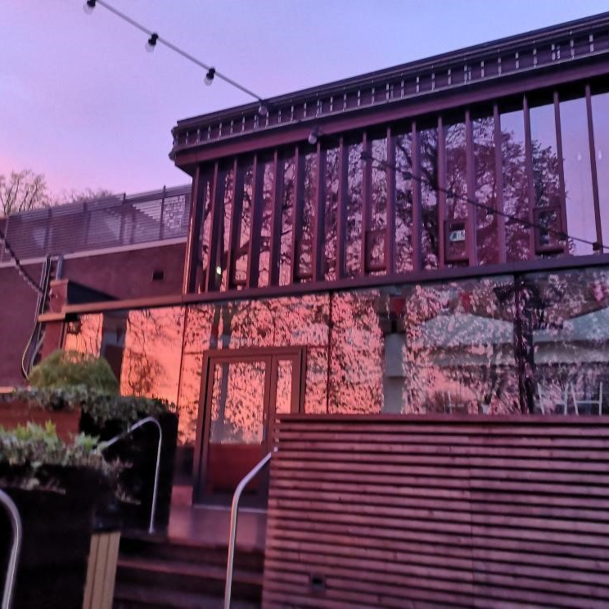 Exterior of dining hall and terrace at sunset