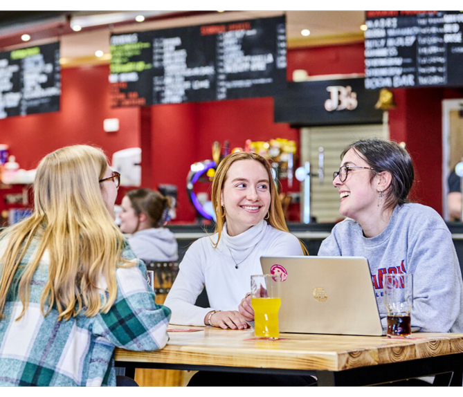 Three students sitting having a chat in the college bar