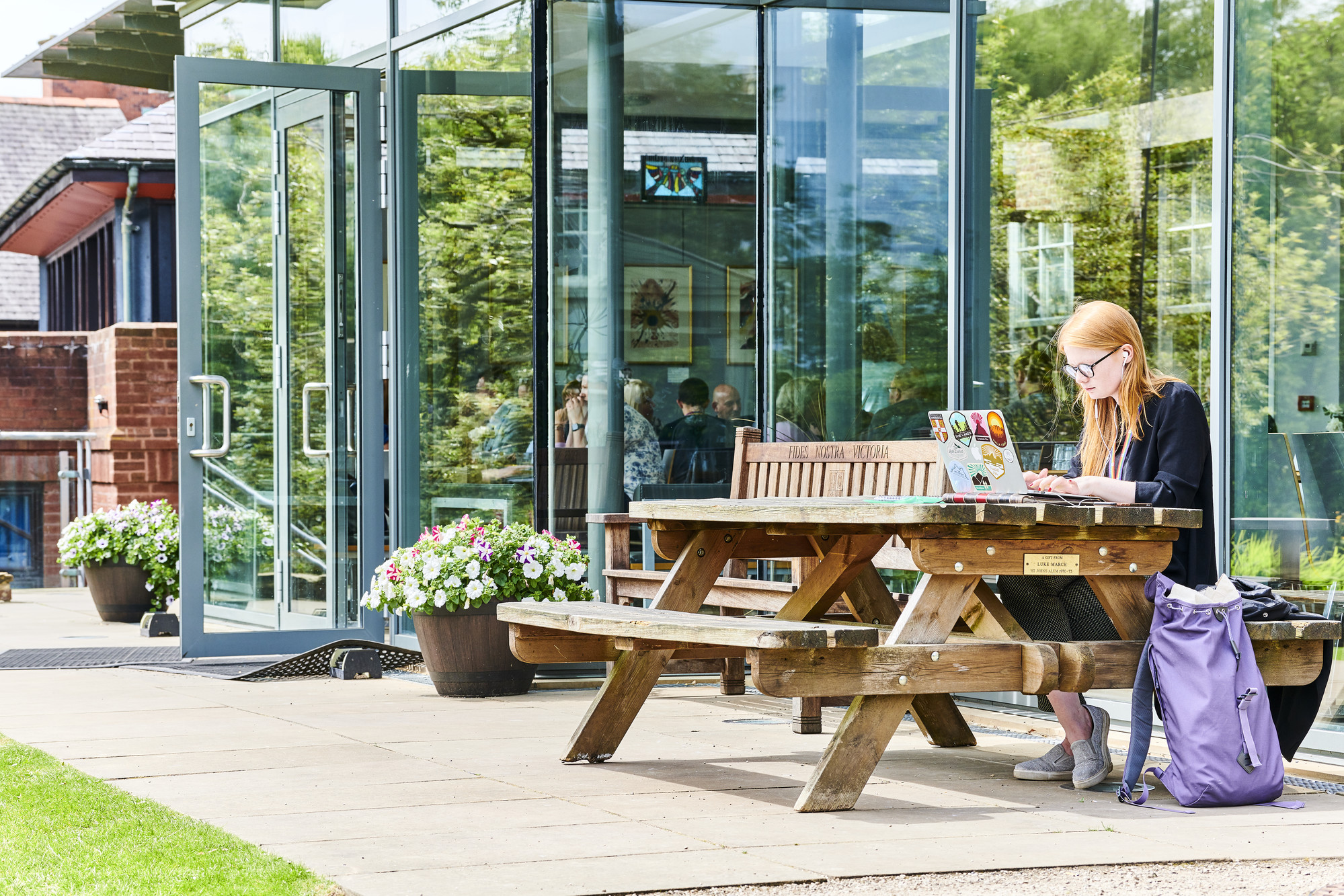 Student sat at a bench on a laptop