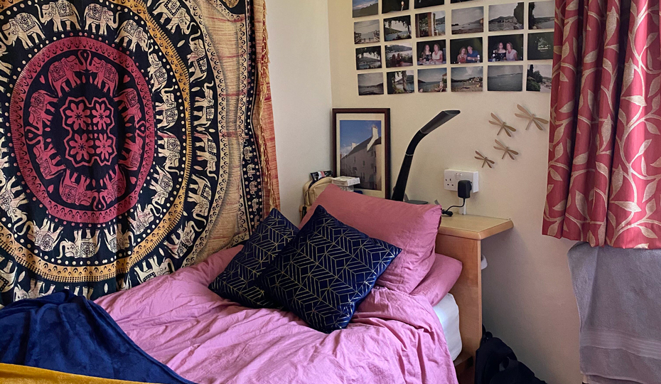 The sleeping area of a single room at Parson's Field site with decorations and photos on the wall.