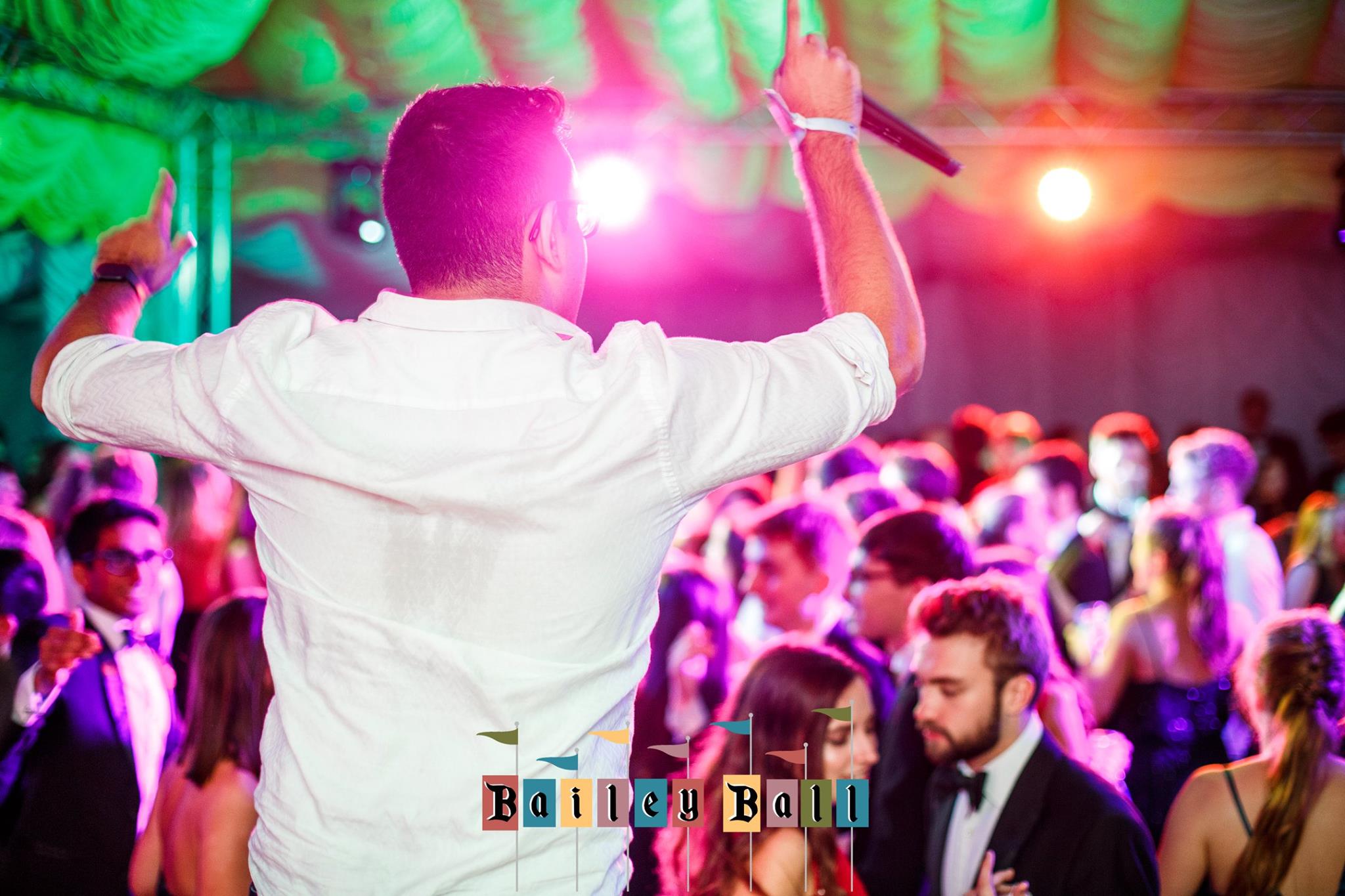 Entertainer with a microphone in front of a crowd of students