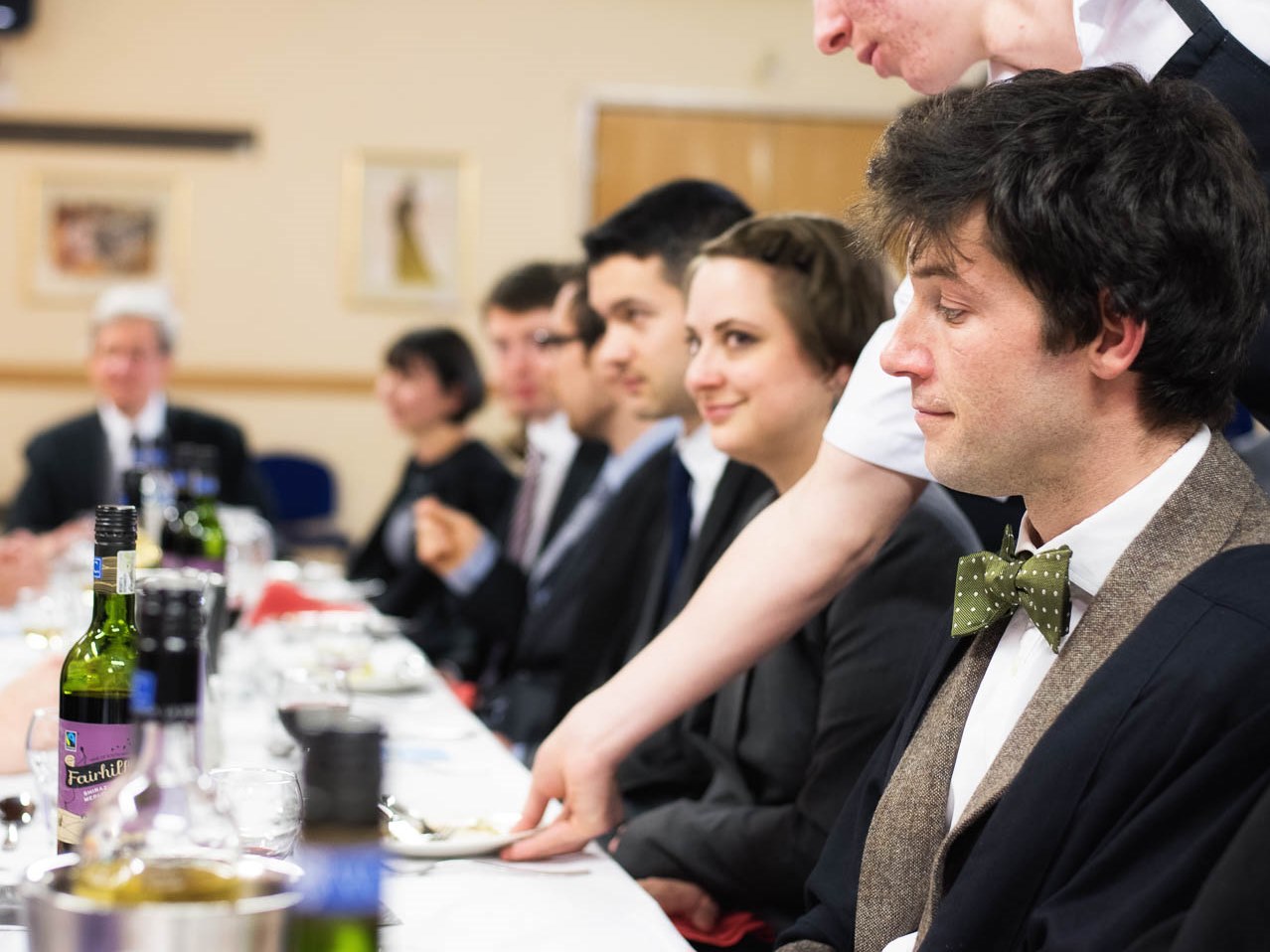 Staff sitting round a table enjoying wine and an evening meal