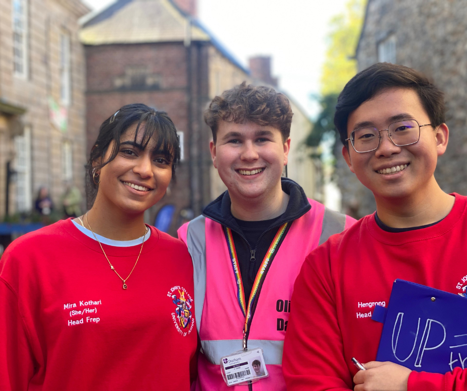 three smiling students outside