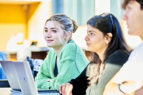 two female students sitting at a laptop.