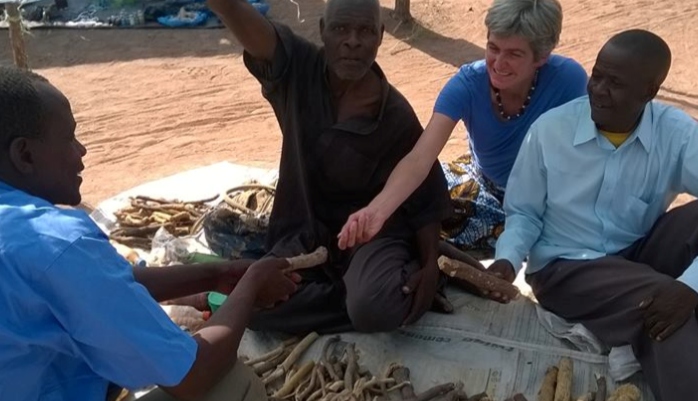 four people sitting on the ground chatting