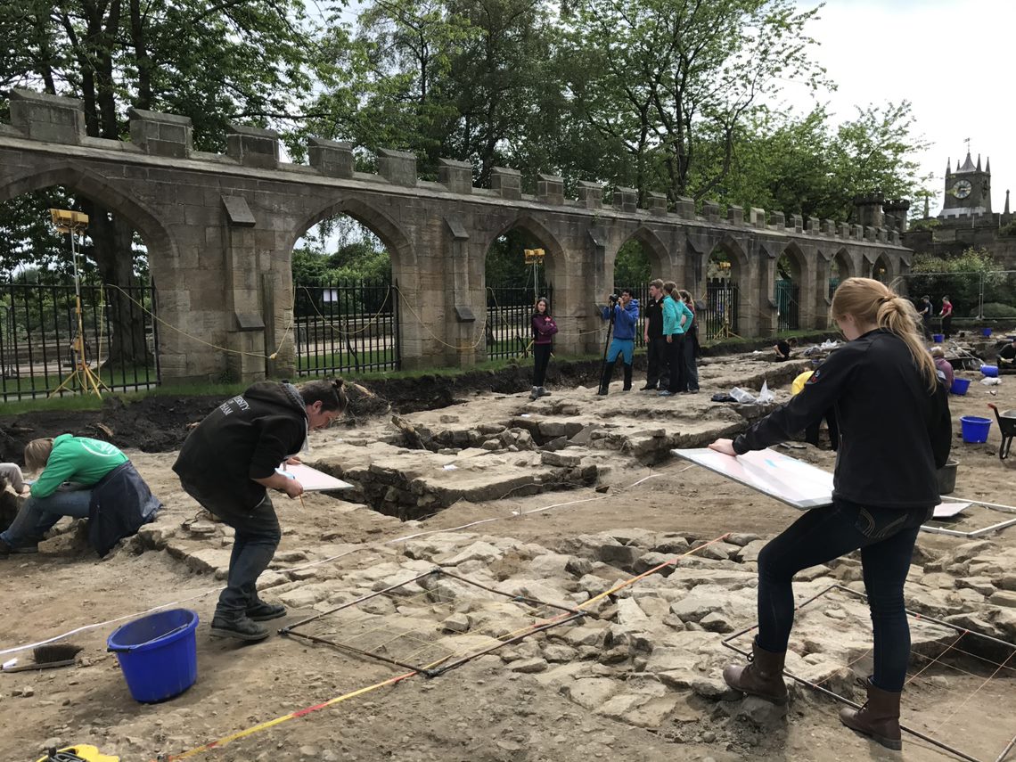 Students excavating and recording archaeological features